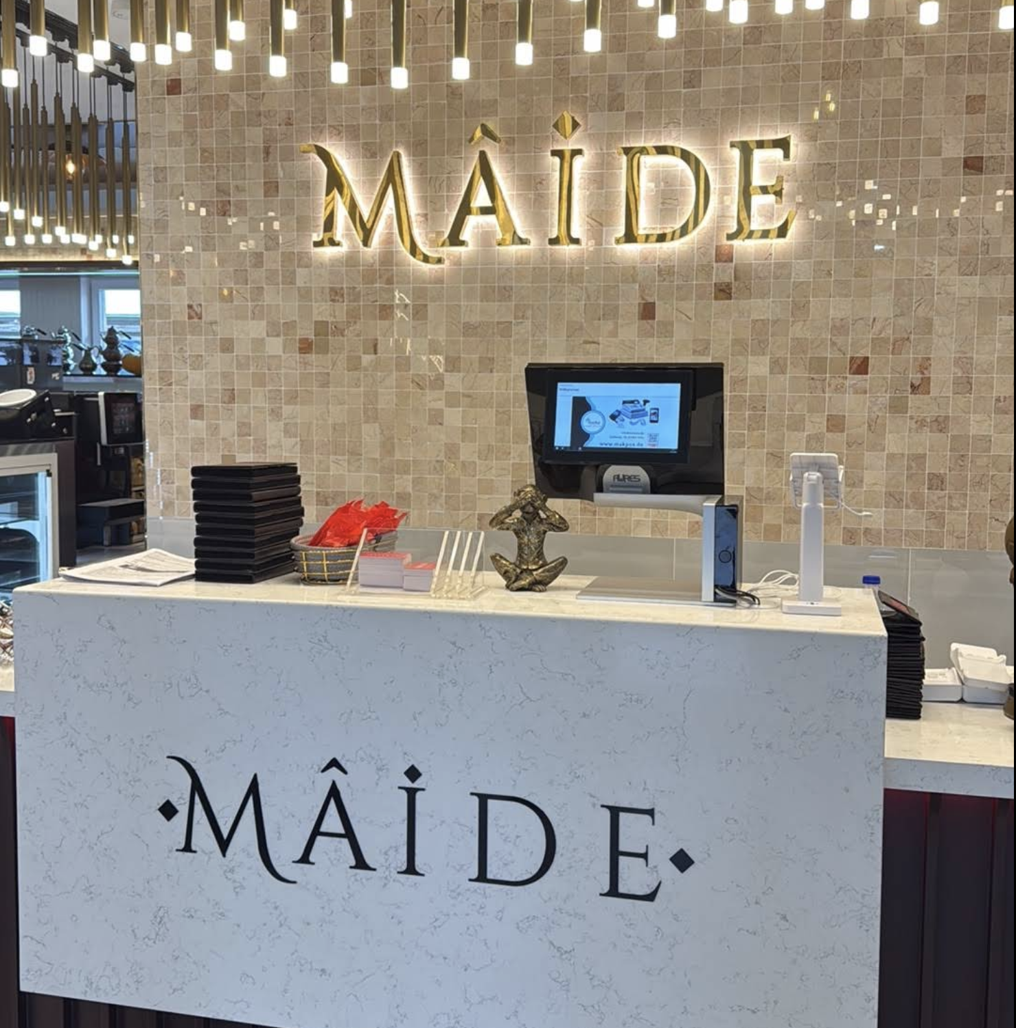 Empfangstresen mit goldenem MÂIDE Logo